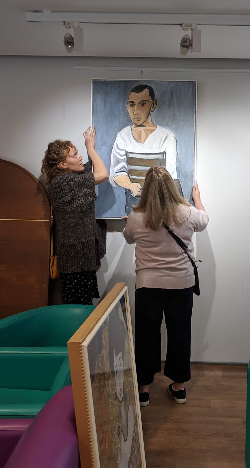 Oil canvases being hung at the National Spinal Injuries Centre
